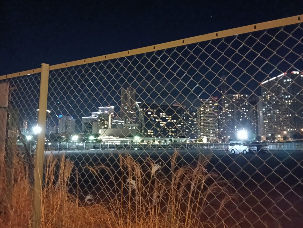 金網の向こうの高層ビル群。みなとみらい付近。現場近くで撮影。