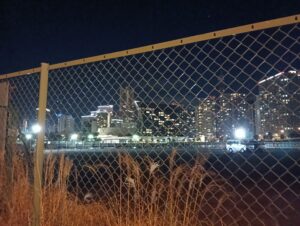 金網の向こうの高層ビル群。みなとみらい付近。現場近くで撮影。