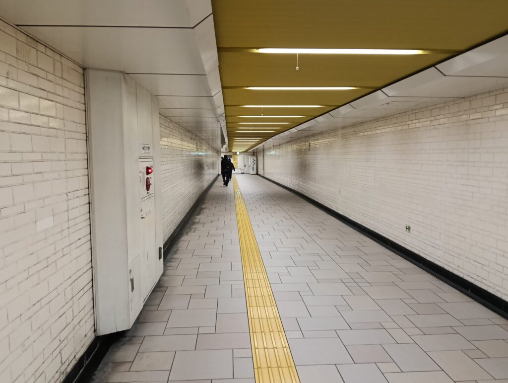 地下鉄駅の長く続くコンコース。誰もいない無機質な通路。